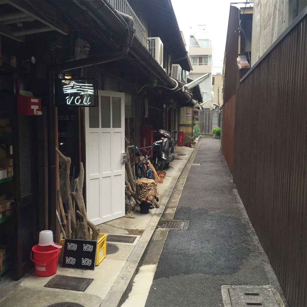 四条烏丸時代のVOUの外観。路地に建つ店にネオンのロゴ看板が光っている